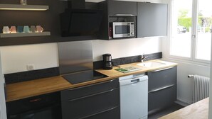A modern kitchen with a built-in microwave, a coffee machine, and a dishwasher.