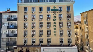 Un edificio de varios pisos con un letrero que dice "HOTEL OSMANBEY" y varias unidades de aire acondicionado.