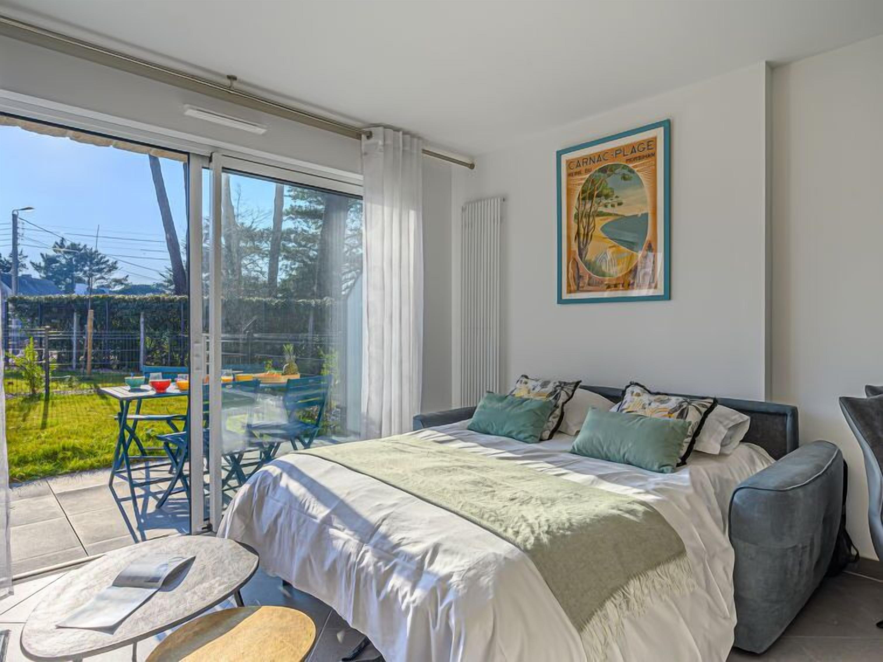 Un dormitorio con una cama grande, vistas al exterior y un cuadro en la pared.