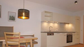 A modern kitchen with white cabinets, a built-in oven, and a pendant light. - Freiheit-La by Interhome (Pettneu am Arlberg)