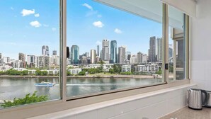 Una cocina con un ventanal que da a un horizonte urbano y un río.