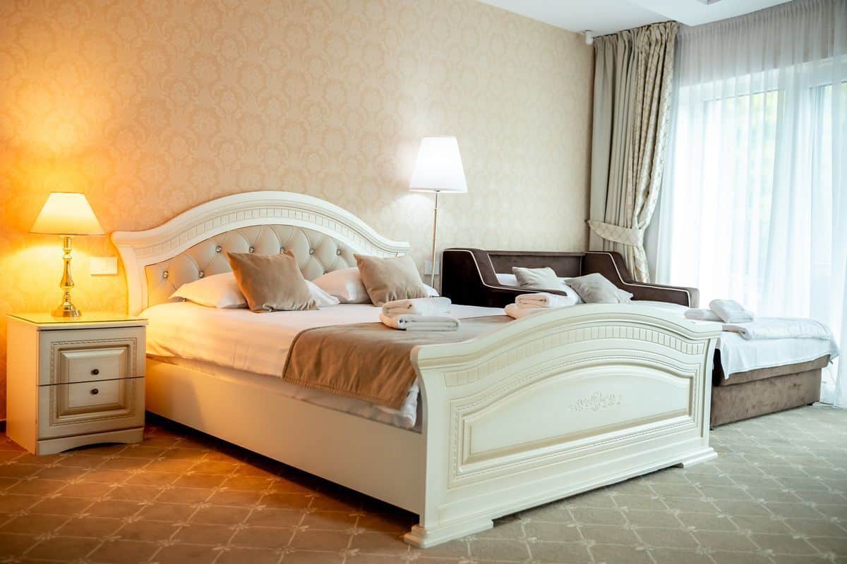 Une chambre à coucher bien rangée, avec un grand lit, des tables de chevet et une petite table de nuit.