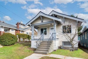 A two-story house with a front porch, a small front yard, and a visible mailbox. - 4016 Main (NEW) · 5b2b Newly Remodeled Entire House close to UW & DT (Seattle)