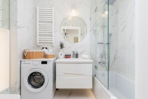 Bathtub, hair dryer, towels, shampoo