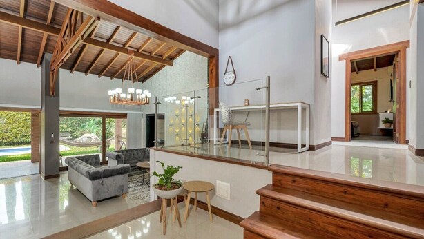 A spacious living area with a modern design, a staircase, and a view of the outdoors. - 4BR Villa Heated Pool Private Nightclub-El Poblado (Medellín)