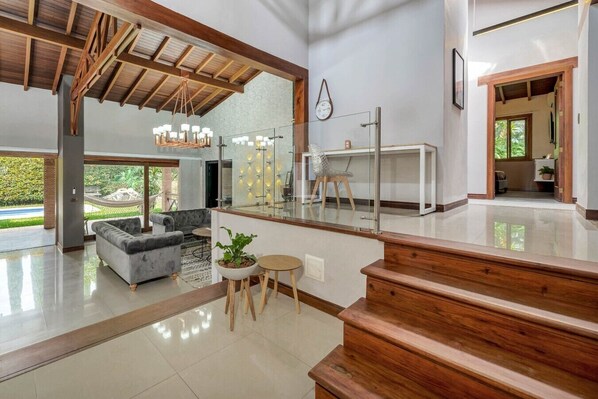 Un espacio habitable espacioso con diseño moderno, una escalera y vistas al exterior.