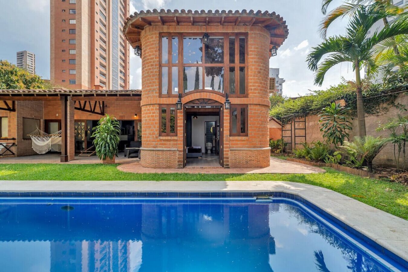 A brick building with a pool in front.