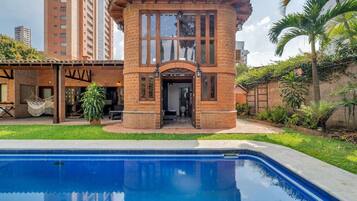 A brick building with a pool in front.