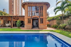 A brick building with a pool in front.