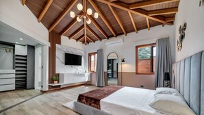 A spacious bedroom with a large bed, a built-in TV, and a wooden ceiling. - 4BR Villa Heated Pool Private Nightclub-El Poblado (Medellín)