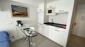 Une petite cuisine équipée d’un four à micro-ondes, d’un évier et d’une petite table à manger.