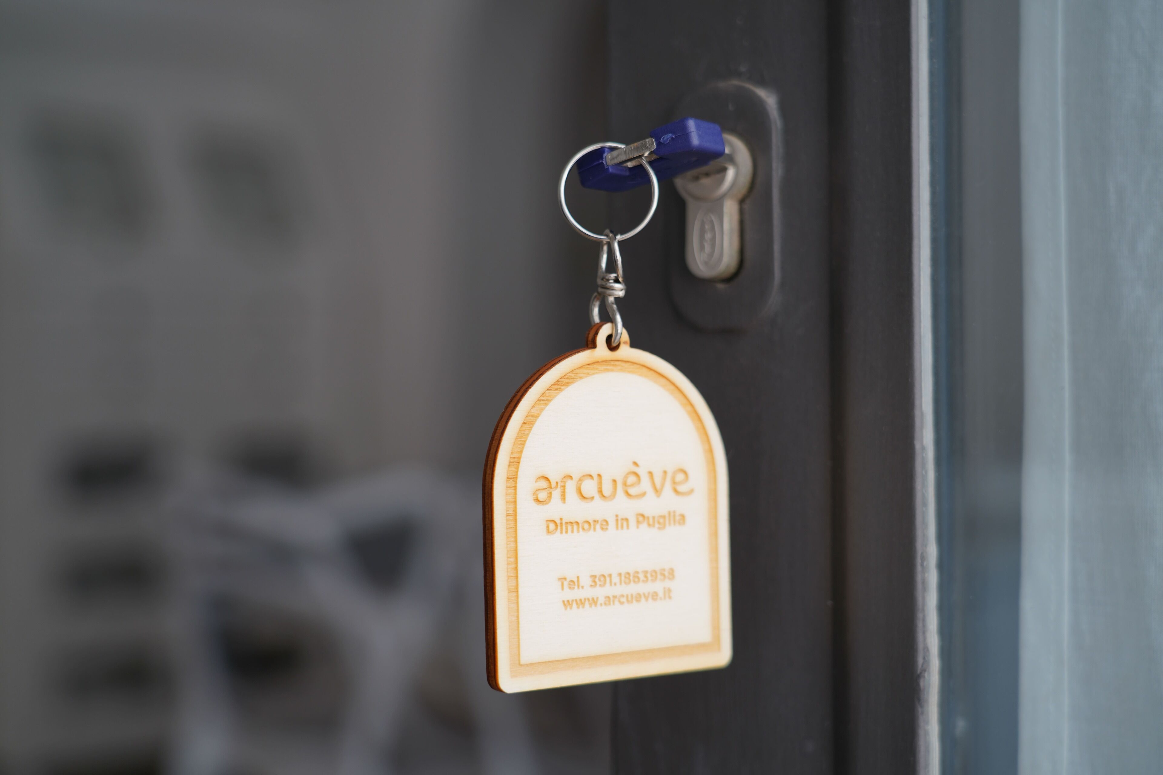 A keychain with the text "arcuvé" and contact information.