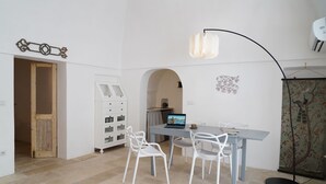 Ein Essbereich mit Tisch, Stühlen, einem Laptop und einer Wanddekoration.