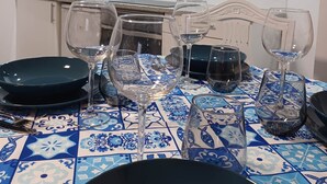 A modern kitchen with white cabinets, a stainless steel microwave, and a tiled backsplash. - Casa Típica no Centro do Porto (PORTO)