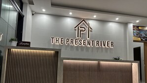 A reception desk with a sign that reads "The Present River." - The Present River Hoi An  (Da Nang)