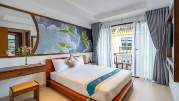 Habitación de hotel con una cama grande, un escritorio de madera, un banco, un espejo amplio y vistas al balcón exterior.