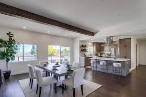 Una cocina moderna con una isla central, muebles blancos y electrodomésticos de acero inoxidable.