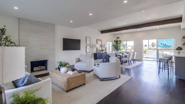 Una sala de estar moderna con chimenea, zona de estar y comedor con vistas.