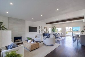 Una sala de estar moderna con chimenea, zona de estar y comedor con vistas.