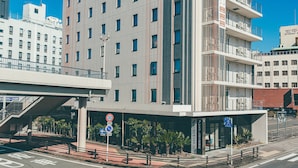 A modern hotel with a multi-story structure, a covered entrance, and a pedestrian walkway. - Kuretake-inn Premium Fujinomiya (Fujinomiya)