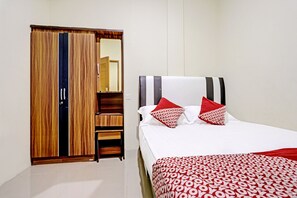 A bedroom with a bed, a wardrobe, and a mirror. - Spot On 91500 Suci Homestay Syariah (Batam)