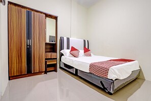 A bedroom with a bed, a wardrobe, and a mirror. - Spot On 91500 Suci Homestay Syariah (Batam)