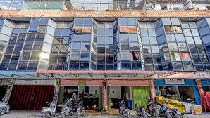 A multi-story building with a ground-level shop and several motorcycles parked in front. - Spot On 91500 Suci Homestay Syariah (Batam)