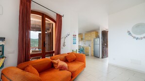 Ein Wohnzimmer mit einer Couch, einem Essbereich und einer Küche.
