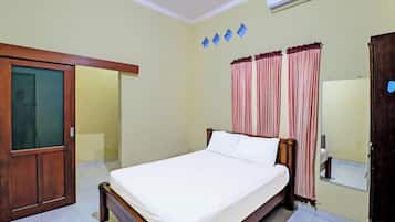Quarto com cama, guarda-roupa, espelho e ar condicionado.