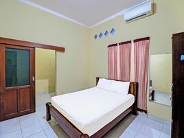 Quarto com cama, guarda-roupa, espelho e ar condicionado.