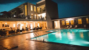 Un hotel con piscina, zona de estar al aire libre y bar/salón.