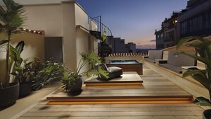 Terraço no telhado com mesa de bilhar, área de estar e plantas em vasos.