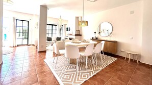 A spacious living area with a dining table, chairs, and a patterned rug. - Endless Summer Beach House, Atlanterra (AN)