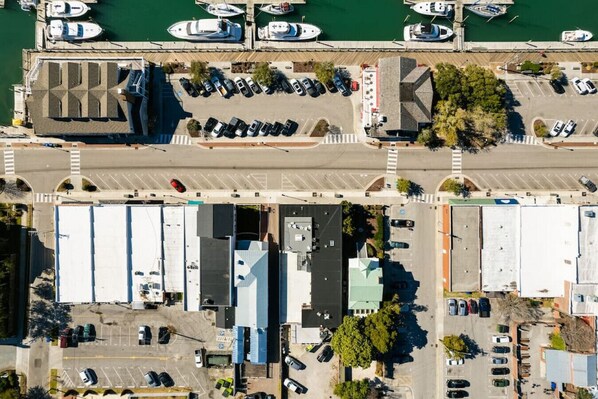 Ein Luftbild eines Yachthafens mit angestaubten Booten, einem Parkplatz und Gebäuden mit flachen Dächern.