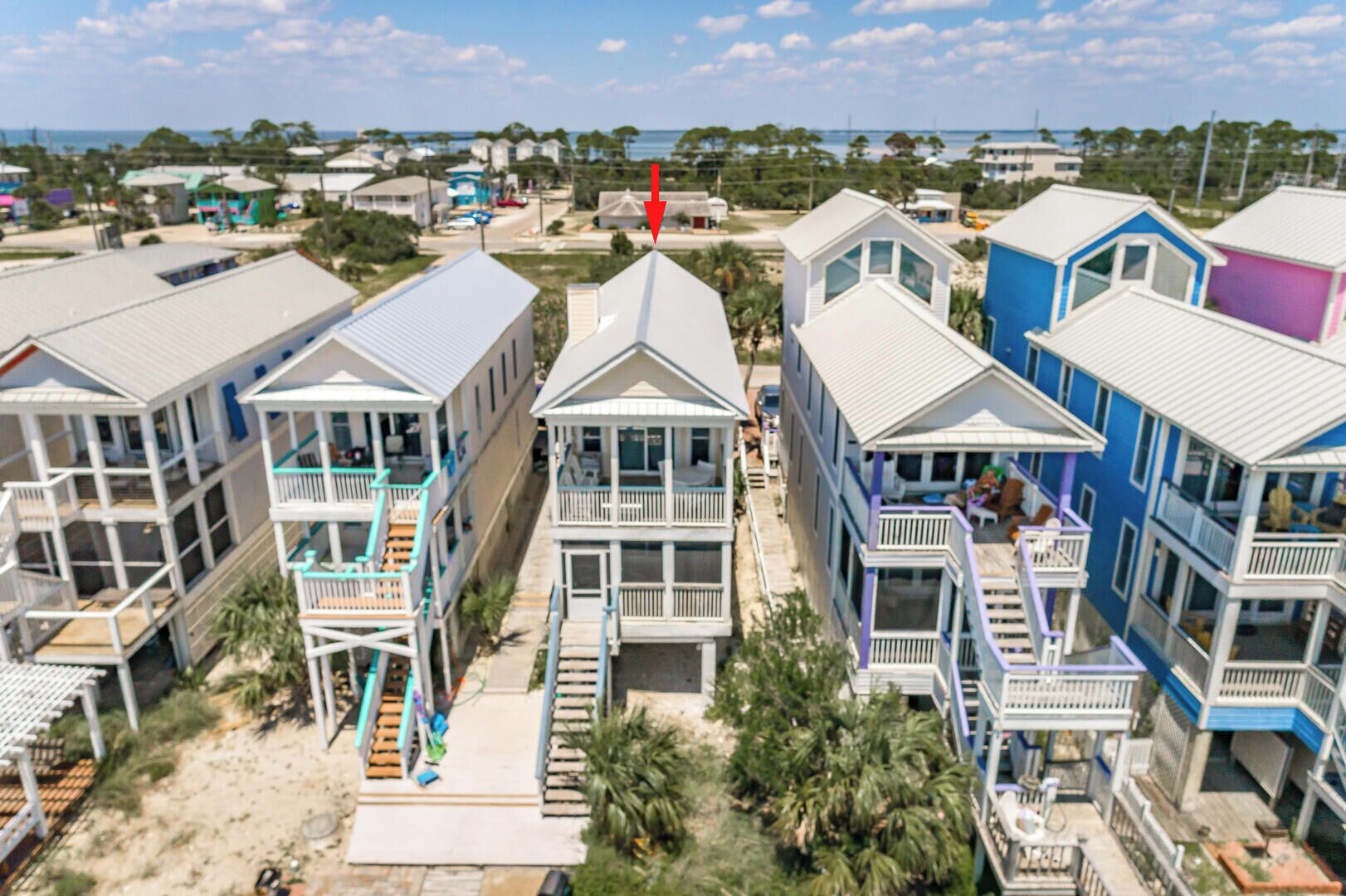 A coastal residential area with beachfront houses featuring balconies and a view of the ocean.