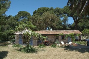 A rustic house with a tiled roof, surrounded by trees and a garden. - Villa in the countryside in a wooded property (Ile de Porquerolles)