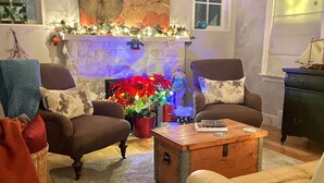 A cozy living room with a fireplace, comfortable seating, and festive decorations. - Walk to Victoria Hospital - fenced yard - quiet neighbourhood (London)