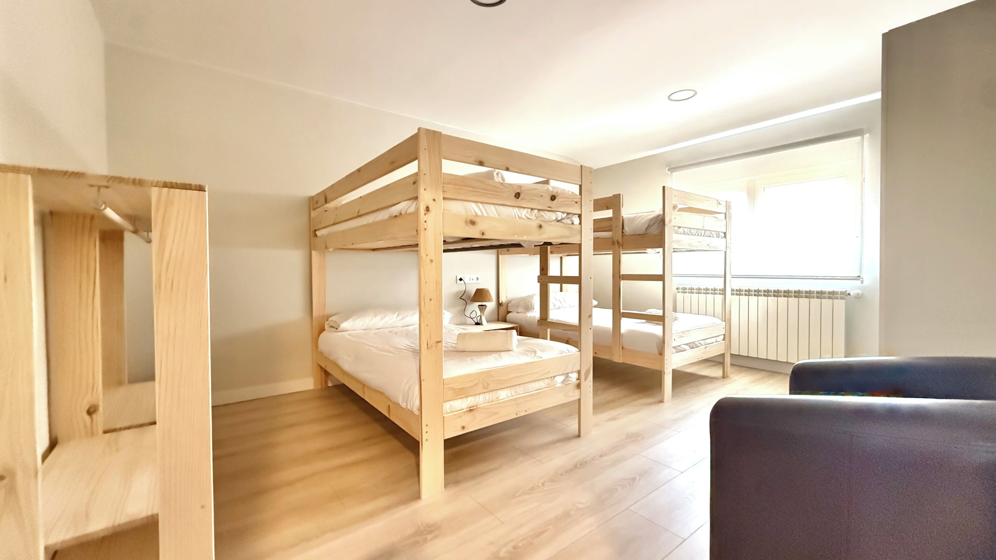 A room with bunk beds, a desk, and a window.