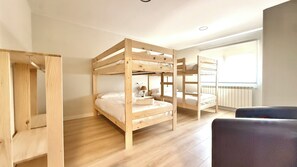 A room with bunk beds, a desk, and a window. - Apartamentos Pantón Ribeira Sacra (Panton)