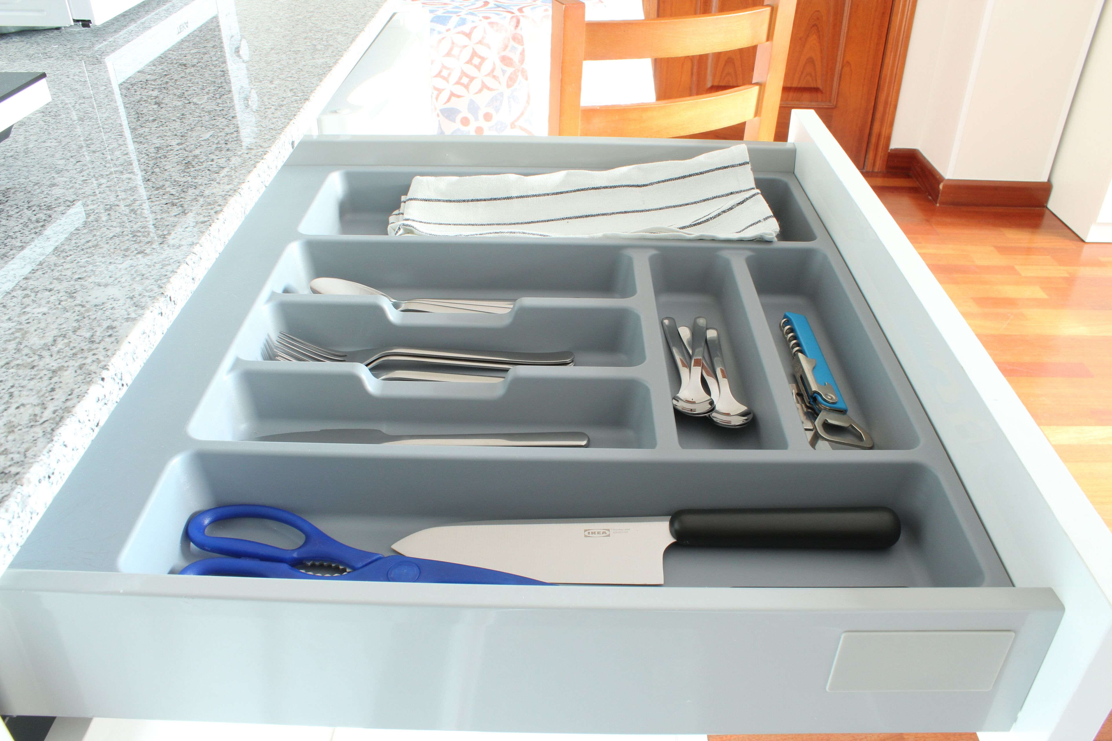 A kitchen drawer with various utensils and kitchen tools.