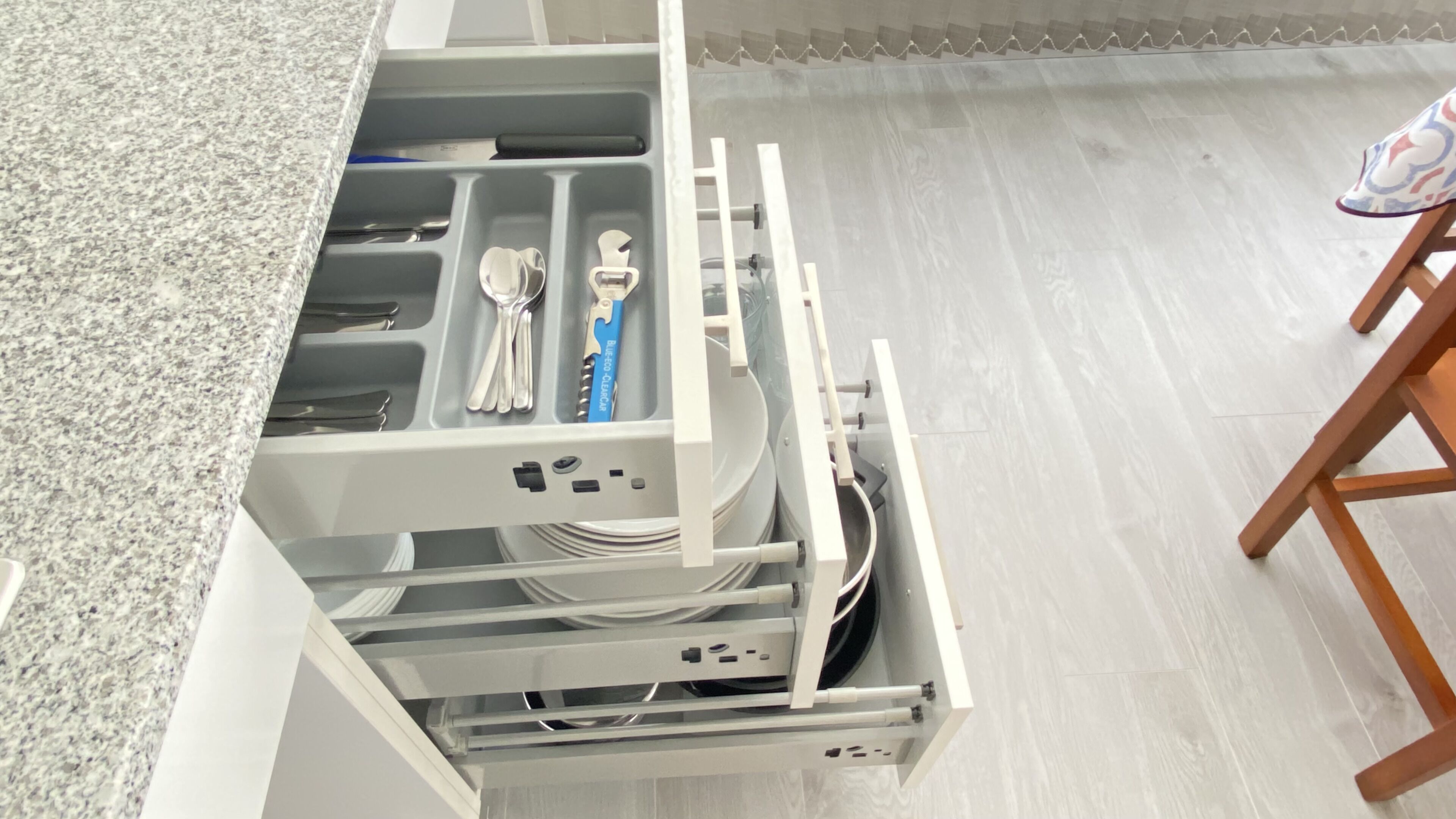 A kitchen drawer with utensils and a dish rack.