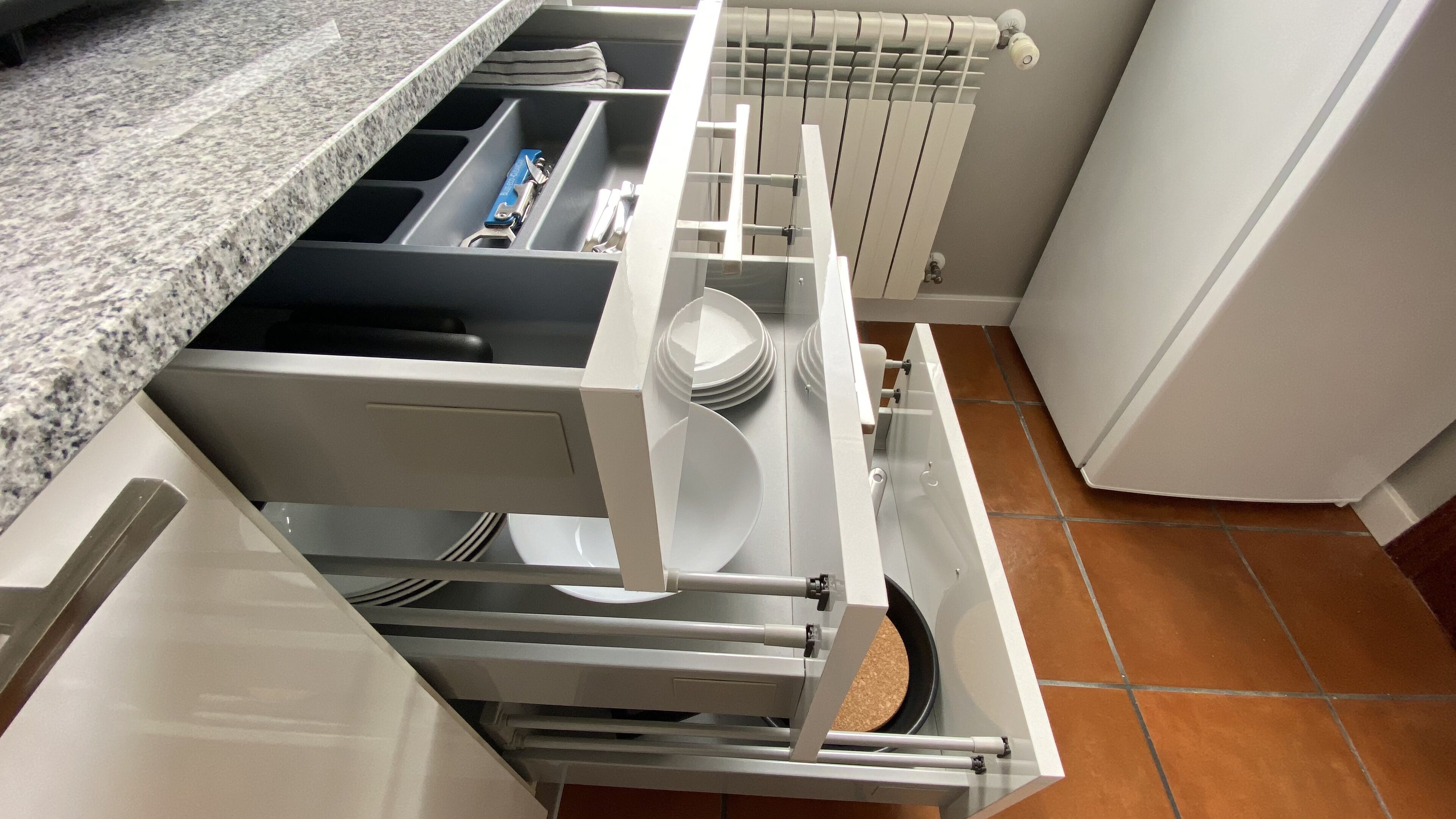A kitchen with a built-in dishwasher, a granite countertop, and a tiled backsplash.