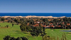 A golf course with a desert landscape and a view of the ocean. - Excellent bungalow in Maspalomas (Maspalomas)