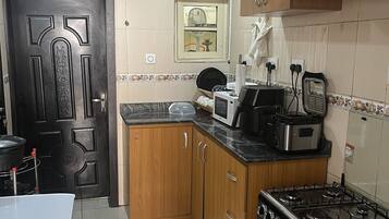 A modern kitchen with wooden cabinets, a gas stove, a microwave, and a sink.
