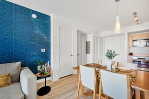Enjoy a stylish living space with a nautical-themed map, comfortable sofa, and dining area.