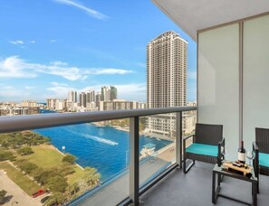 A balcony with a view of a city skyline and a body of water.