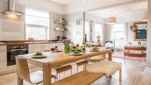 A modern kitchen with wooden countertops, a dining table set for four, and a bench. - 3 St Nicholas Court, Aldeburgh (Aldeburgh)