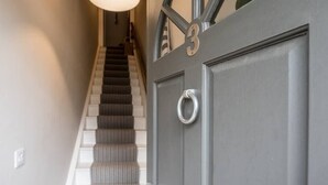 A staircase leading to a door with the number 3, a light fixture above, and a doorbell. - 3 St Nicholas Court, Aldeburgh (Aldeburgh)