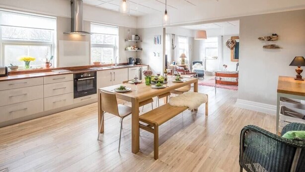 A modern kitchen with wooden cabinets, a central island, and pendant lighting. - 3 St Nicholas Court, Aldeburgh (Aldeburgh)