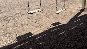 Une structure en bois avec une balançoire, donnant sur une plage.
